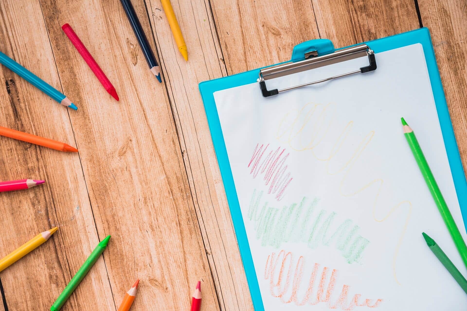 colorful pencil clipboard with white paper wooden table (1)